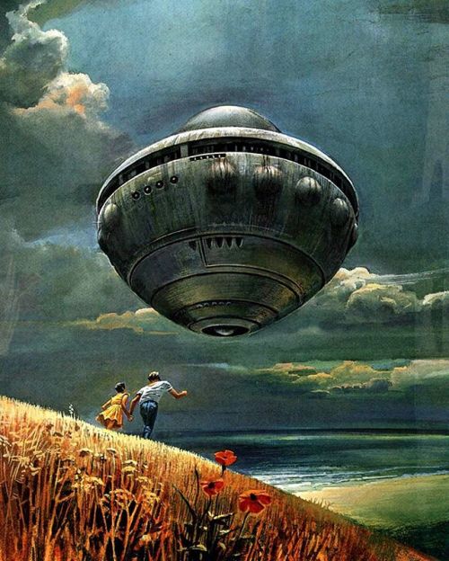A massive, metallic, acorn-shaped spaceship hovers in a dark, cloudy sky above a coastal landscape. In the foreground, a boy and a young girl in a yellow dress run toward the vessel across a golden, flower-filled hillside.