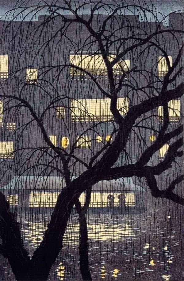 A Japanese woodblock print depicting a silhouetted willow tree with drooping branches framing a night scene. In the background, warm yellow light glows from the windows of a riverside building, reflecting on the dark water below.